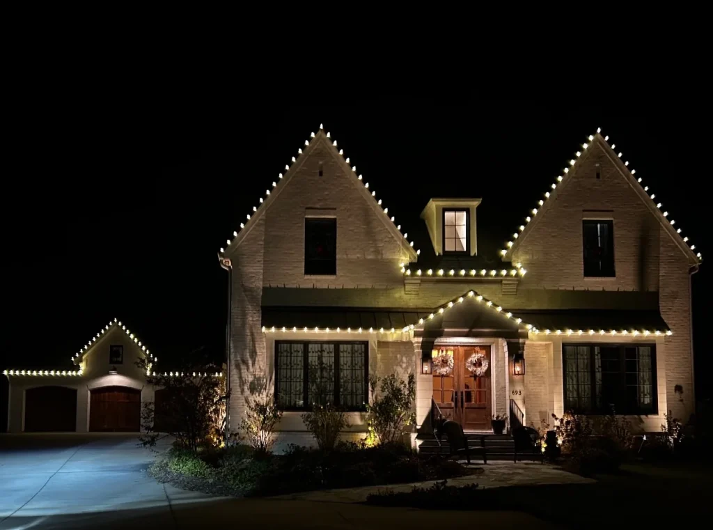 Classic warm white holiday lights tracing rooflines and entry features on a residential home